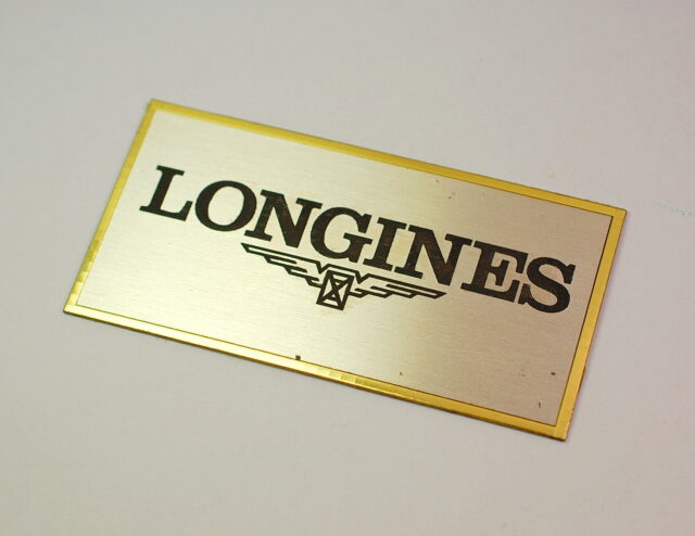 LONGINES placca pubblicitaria adesiva in metallo dorato - presumibilmente anni '70