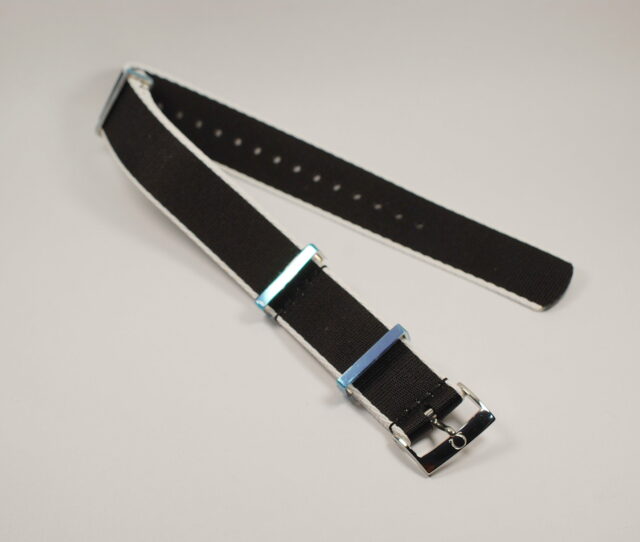 OMEGA NATO type strap, 20 mm made of black polyester with white border, steel loops, complete with steel buckle marked Omega - new of current production.